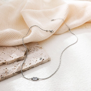Macro detail of silver tone knot chain necklace with rectangular clear zircon stone