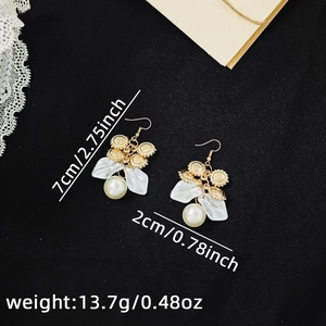 Detailed macro view of retro floral pearl earrings with measurement specs and golden disc