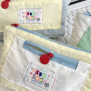 Macro shot of multi-layer fabric pencil case with colorful panels and red zipper pull