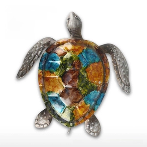 Detail of colorful hand-painted sea turtle wall decor with hammered metallic textures
