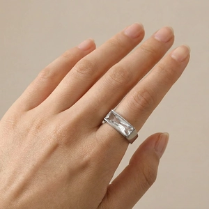Detailed view of wide silver band ring with large rectangular transparent zircon stone