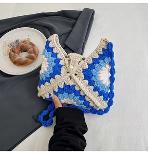 Detail of handmade crochet flower bag featuring vibrant yarn textures and a pearl button