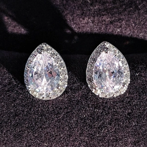 Macro shot of silver pear-shaped halo stud earrings with brilliant-cut clear crystals