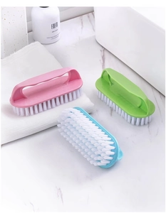 Three colorful multi-functional cleaning brushes with soft bristles on a marble surface