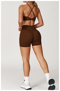 Vista posteriore del set yoga marrone con reggiseno a incrocio e pantaloncini a vita alta