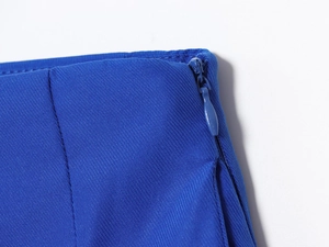 Détail de la fermeture éclair invisible sur jupe midi plissée bleue en tissu sergé