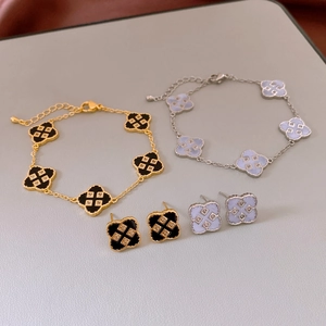 Detail view of gold and silver four-leaf clover bracelets with enamel and zircon inlay