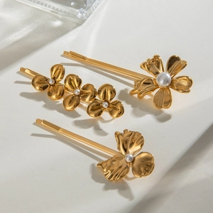 Detailed macro view of three 18k gold flower hair clips with elegant pearl centers