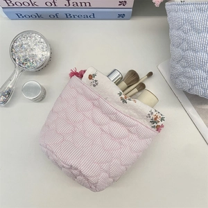 Pink heart quilted drawstring makeup bag with striped design and floral lining