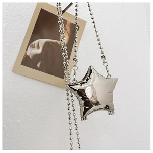 Detail shot of a mini star-shaped metallic bag with a delicate silver ball chain strap