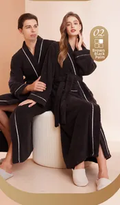 Detail of plush palm black bathrobe with white piping and matching striped slippers