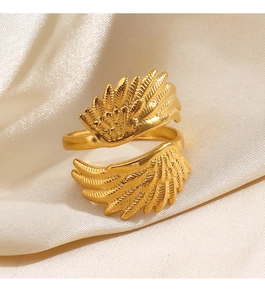 Makroaufnahme des goldenen Flügelrings auf beigem Seidenstoff mit verstellbarem Band