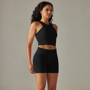 Detail of black seamless knitted sports set featuring a ribbed crop top and high-waist shorts