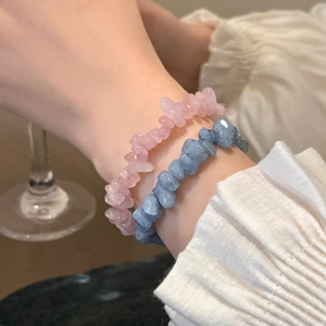 Close-up of aquamarine and camellia beaded elastic bracelets on a woman's wrist
