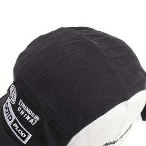 Close-up of white letter embroidery on a black and white color-block baseball cap