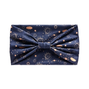Close-up of a dark blue wide headband with golden sun, moon and celestial patterns