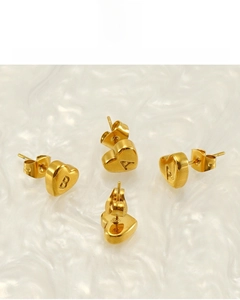 Macro detail of 18K gold plated heart stud earrings with engraved letters A and B