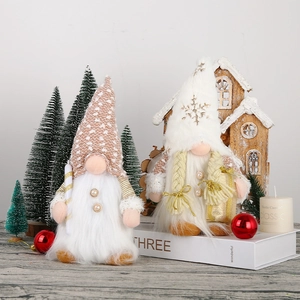 Detailed view of two Christmas gnomes with knit hats and candy cane on a festive desk
