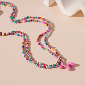 Détail d'un collier de perles colorées avec un pendentif chien ballon rose