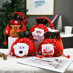 Detailed view of four festive Christmas drawstring gift bags with 3D plush holiday characters