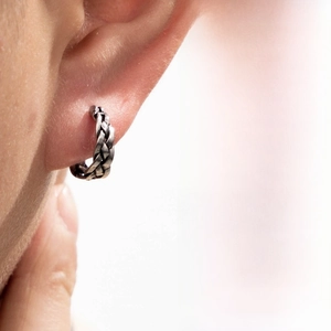 Close-up of vintage braided texture hoop earring in distressed silver on model ear