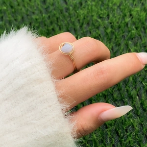 Detail of handcrafted gold wire wrapped ring featuring an oval translucent lavender stone