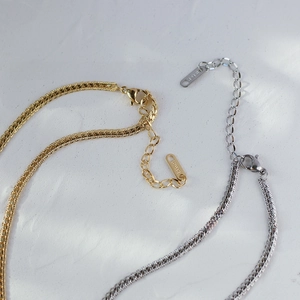 Detail of snake bone chain in gold and silver finish with lobster clasp and 18KGP tag