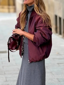 Detail of burgundy satin bomber jacket with leopard print lining and gray knitwear