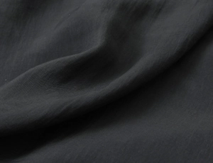 Detailed macro texture of premium black cotton linen poplin fabric with elegant drape