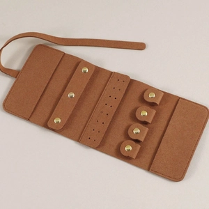 Interieur van bruine microfiber sieradenrol met vakken voor oorbellen en ringen