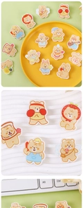Macro shot of cute cream bear acrylic pins in various character designs on a tray