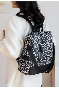 Detail of fashion leopard print backpack with gold zipper and leather fringe tassel