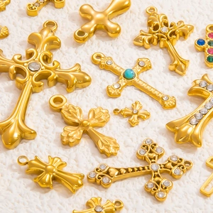 Dettagli macro di ciondoli a croce in oro 18 carati con trame vintage e turchesi