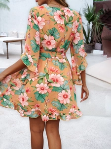 Detail of floral chiffon mini dress featuring back view and ruffled hem in orange