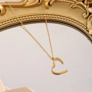 Elegant 18K gold-plated stainless steel heart pendant necklace on a vintage mirror