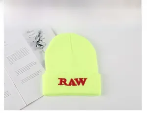 Detail of red RAW embroidery on a neon green knitted beanie with a streetwear style