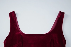 Detailed close-up of wine red velvet fabric showing square neckline and smooth texture
