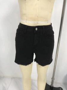 Detailansicht des ausgefransten Saums und der Denim-Textur schwarzer Shorts