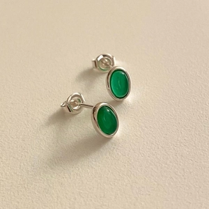 Detailed macro view of 925 sterling silver stud earrings with oval green agate gemstones