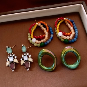 Detailed set of vintage earrings featuring colorful beads, rhinestones, and metallic hoops
