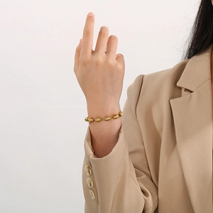 Bracciale da donna in oro 18 carati con perline geometriche indossato sul polso di una modella