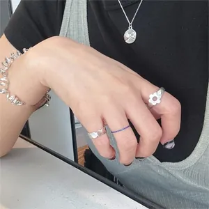 Chic 925 sterling silver flower rings and bracelets set worn by a model in casual style