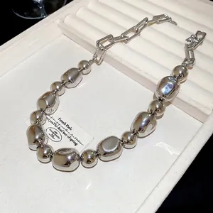 Collier de perles argentées irrégulières avec chaîne épaisse sur plateau en velours