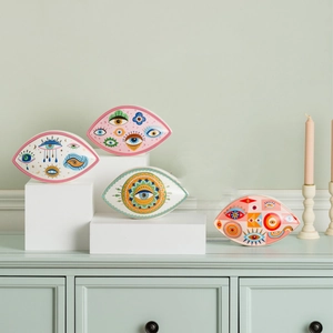 Artistic ceramic evil eye ornaments displayed with candles for elegant home decor