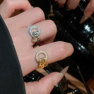 Detail of elegant sparkling zircon ring with textured metal pendant on a model's hand