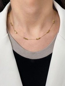 Close-up of minimalist 18K gold-plated beaded chain necklace worn on a female model