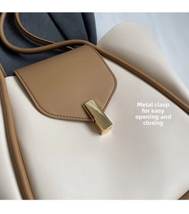 Dettaglio della chiusura in metallo dorato su borsa tote grande bicolore elegante
