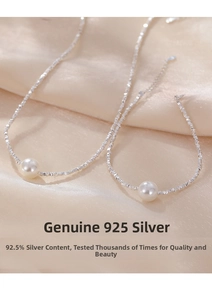 Detail of 925 sterling silver crushed silver chain with white pearl on silk background