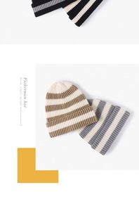 Détail de la maille côtelée du bonnet rayé montrant les motifs marron, gris et noir