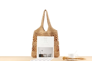 Detail of hand-woven paper rope tote bag with minimalist hollow mesh pattern design